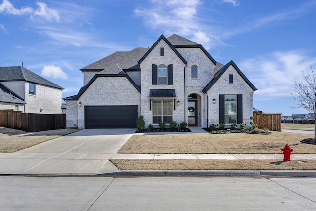 french country inspired facade featuring driveway, stone siding, fence, a garage, and brick siding