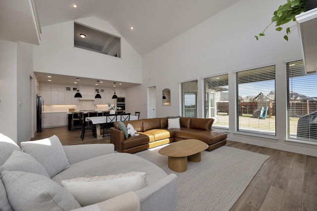 living area with recessed lighting, wood finished floors, and vaulted ceiling