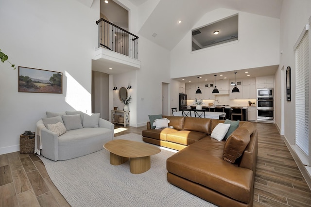 living room featuring recessed lighting, a high ceiling, baseboards, and wood tiled floor