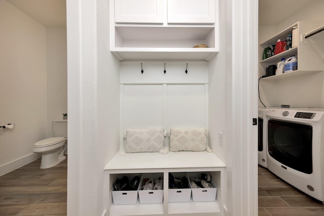 clothes washing area featuring baseboards, wood tiled floor, washer / dryer, and laundry area