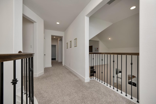 corridor featuring visible vents, baseboards, carpet, lofted ceiling, and recessed lighting