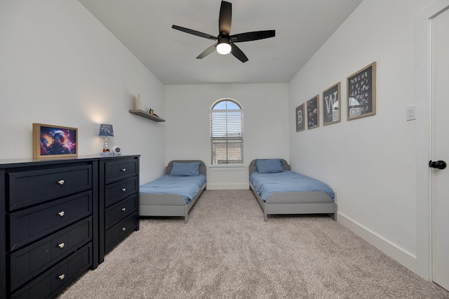 bedroom with ceiling fan, baseboards, and light carpet