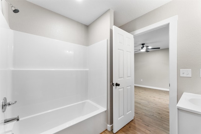 bathroom with vanity, wood finished floors, washtub / shower combination, and ceiling fan