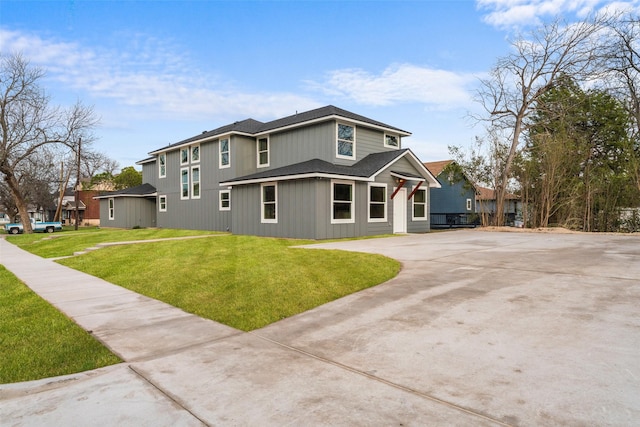 view of front of house featuring a shingled roof and a front yard