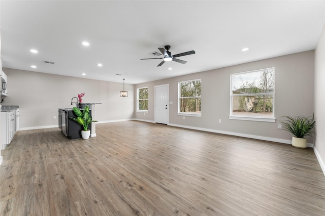 unfurnished living room with recessed lighting, baseboards, a ceiling fan, and light wood finished floors