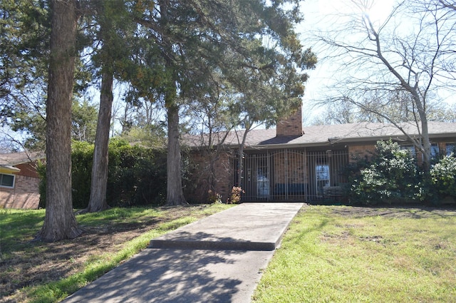 ranch-style house featuring a front lawn and a chimney