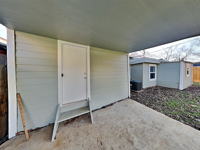 property entrance with central AC unit and a patio area