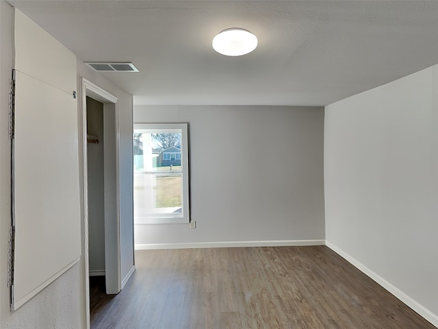 unfurnished bedroom with visible vents, baseboards, and wood finished floors