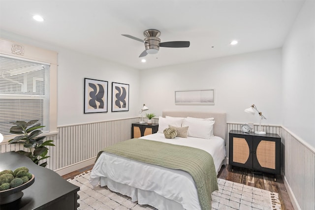 bedroom with a ceiling fan, recessed lighting, wood finished floors, and wainscoting