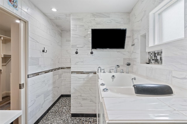 bathroom featuring recessed lighting, a walk in shower, and a garden tub