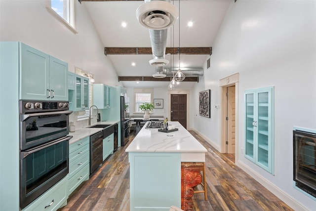 kitchen with a sink, high vaulted ceiling, dark wood finished floors, and a center island