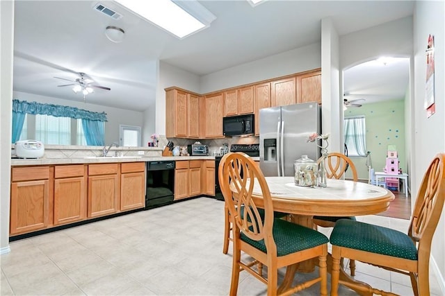 kitchen with tasteful backsplash, visible vents, black appliances, a ceiling fan, and a sink