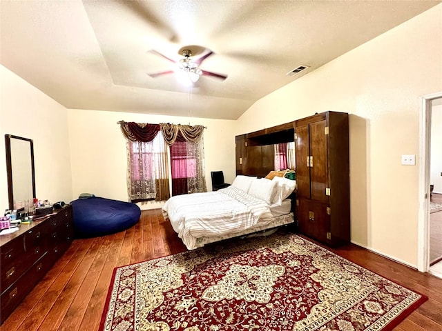 bedroom featuring visible vents, wood-type flooring, a ceiling fan, and vaulted ceiling