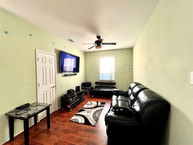 living area with ceiling fan, visible vents, and dark wood-style floors