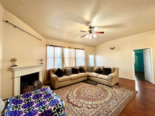 living room with a fireplace, vaulted ceiling, wood finished floors, and a ceiling fan