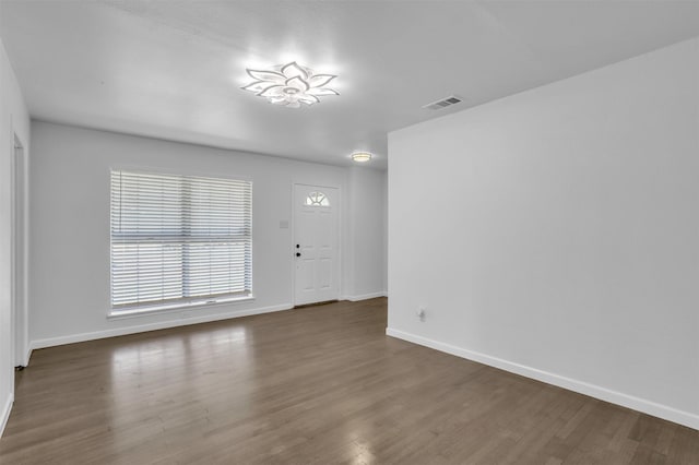 unfurnished living room featuring wood finished floors, baseboards, and visible vents
