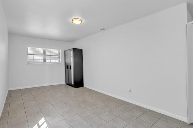 unfurnished room featuring visible vents, baseboards, and light tile patterned flooring