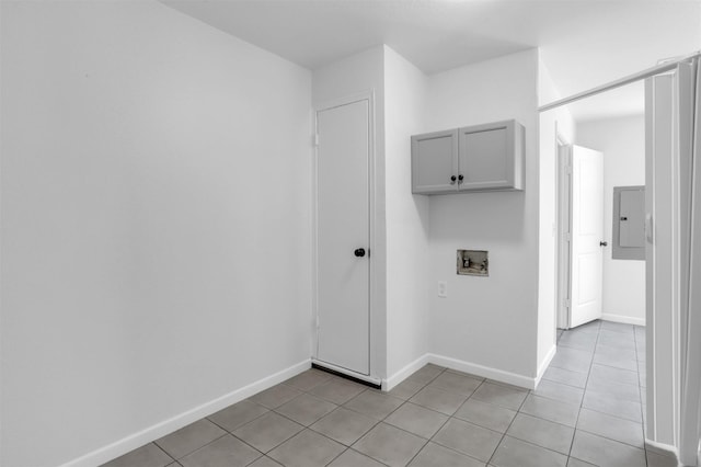 clothes washing area featuring cabinet space, baseboards, light tile patterned flooring, and washer hookup
