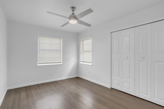 unfurnished bedroom featuring a closet, baseboards, a ceiling fan, and wood finished floors