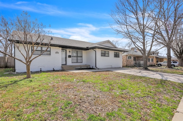 ranch-style house featuring a front yard, brick siding, and fence