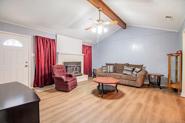 living room featuring a ceiling fan, wood finished floors, visible vents, vaulted ceiling with beams, and a textured ceiling