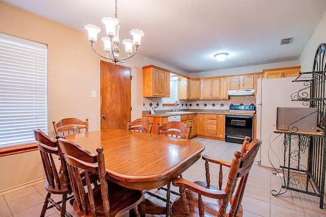 dining space with light tile patterned floors, visible vents, a notable chandelier, and a textured ceiling