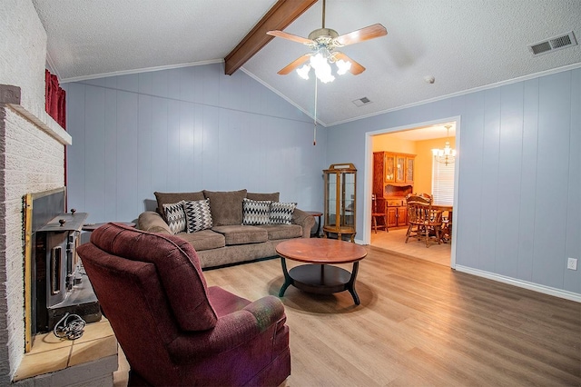 living room featuring visible vents, ceiling fan with notable chandelier, lofted ceiling with beams, and wood finished floors