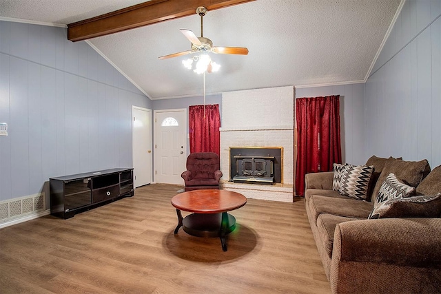 living room featuring visible vents, vaulted ceiling with beams, ceiling fan, and wood finished floors