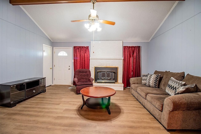 living area with wood finished floors, lofted ceiling, ornamental molding, and ceiling fan