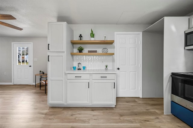 88 Live Oak St, Alvarado, TX 76009 - kitchen with white cabinets, light wood finished floors, range, and light countertops