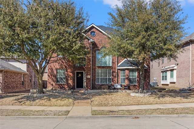 view of front of house featuring brick siding and cooling unit