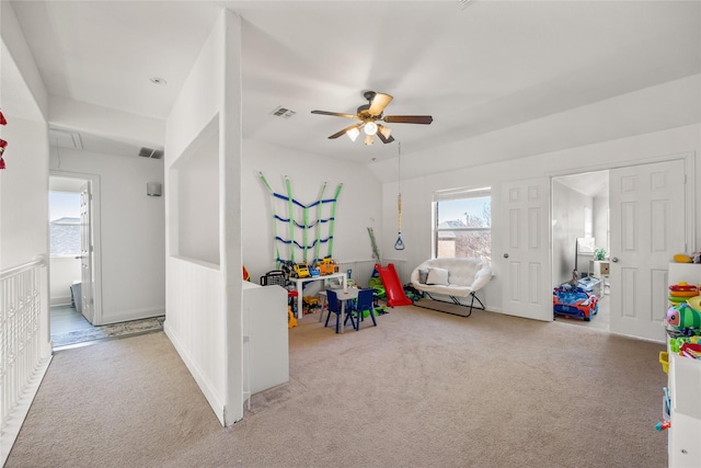 game room with a ceiling fan, visible vents, attic access, lofted ceiling, and carpet flooring