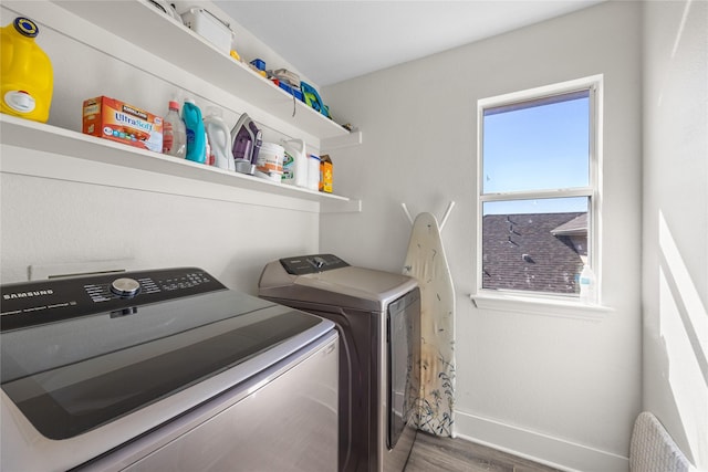 washroom featuring laundry area, wood finished floors, independent washer and dryer, and baseboards