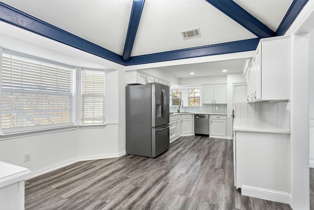 kitchen with dark wood-type flooring, white cabinetry, appliances with stainless steel finishes, light countertops, and baseboards