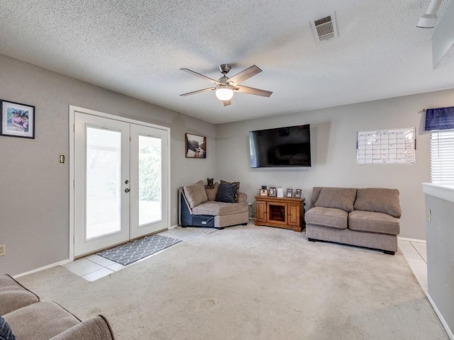 living room with visible vents, a textured ceiling, french doors, carpet floors, and ceiling fan