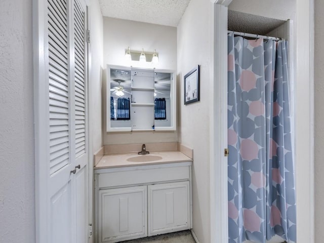 full bath with a textured ceiling, vanity, and a shower with curtain