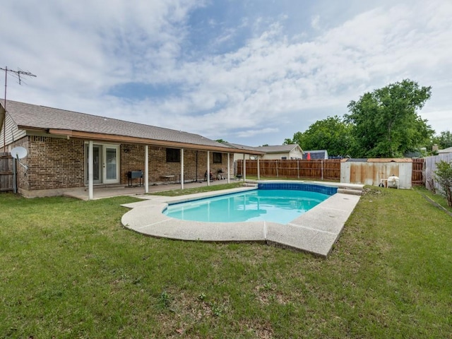 view of swimming pool with a lawn, a fenced backyard, french doors, a fenced in pool, and a patio area