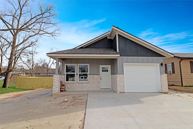 view of front of property featuring board and batten siding, concrete driveway, fence, and a garage