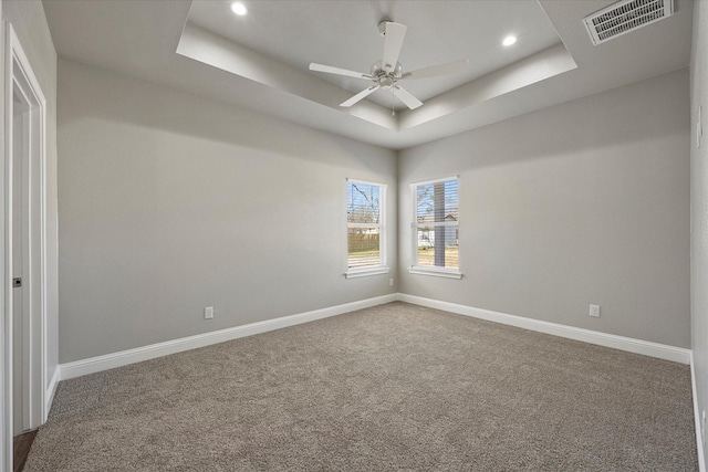 carpeted empty room featuring a ceiling fan, baseboards, visible vents, recessed lighting, and a raised ceiling