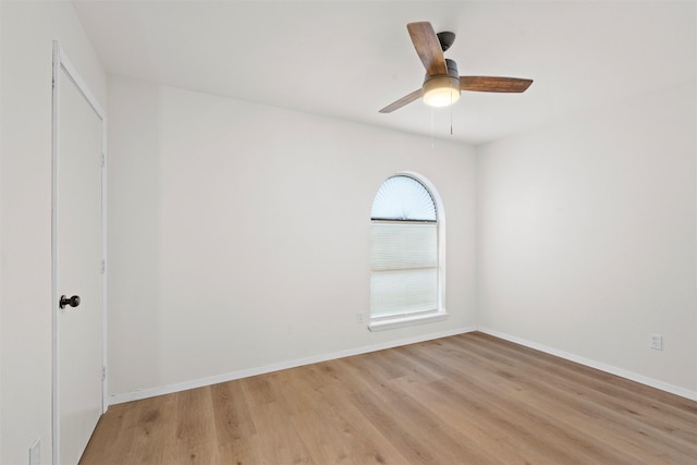 empty room featuring light wood-style flooring, baseboards, and ceiling fan