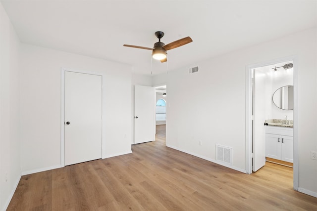 unfurnished bedroom with light wood-style floors, visible vents, and baseboards
