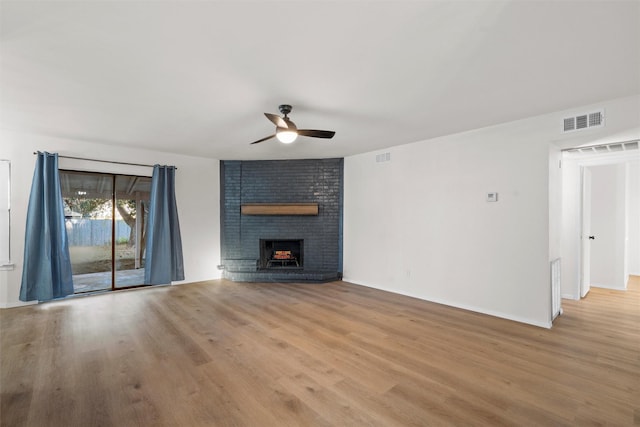 unfurnished living room with visible vents, ceiling fan, a fireplace, and light wood-style flooring