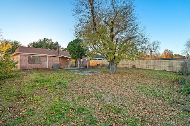 view of yard with central AC unit and a fenced backyard