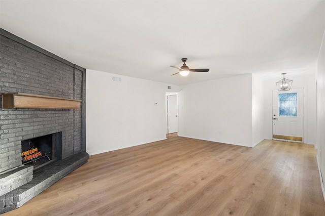unfurnished living room with light wood-style flooring, a fireplace, and visible vents