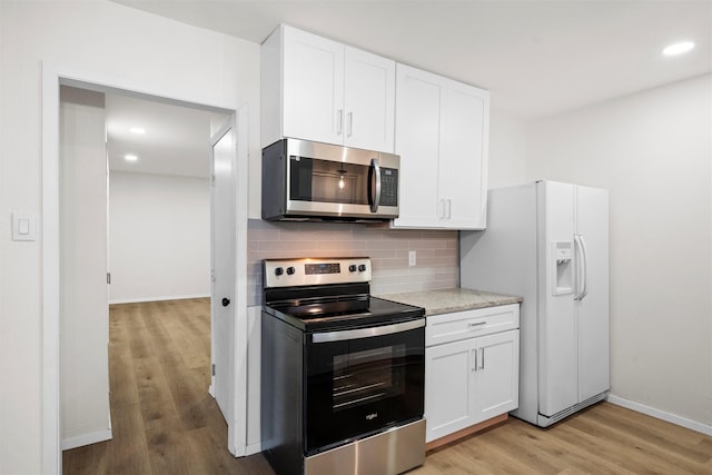 kitchen featuring backsplash, light wood-type flooring, light countertops, appliances with stainless steel finishes, and white cabinets