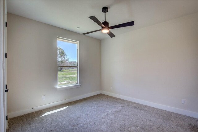 empty room featuring baseboards, a ceiling fan, and carpet