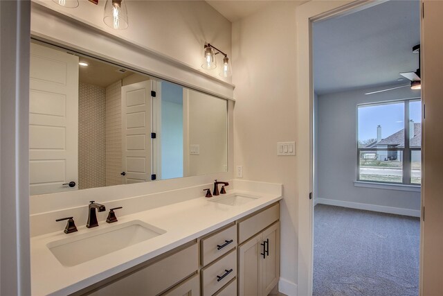 full bathroom featuring baseboards, double vanity, and a sink