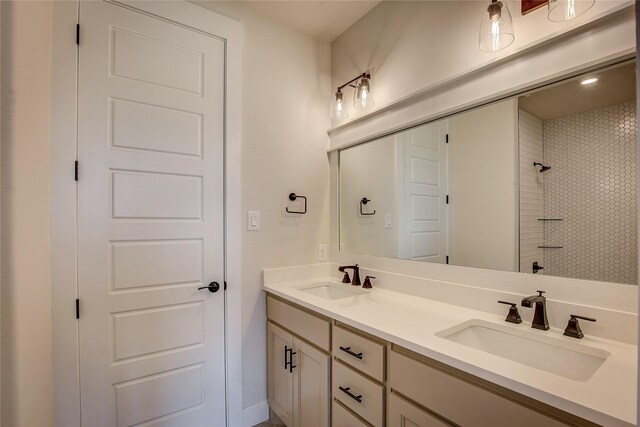 full bath featuring double vanity, a shower, and a sink