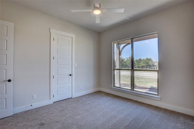 unfurnished room featuring baseboards, carpet flooring, and a ceiling fan