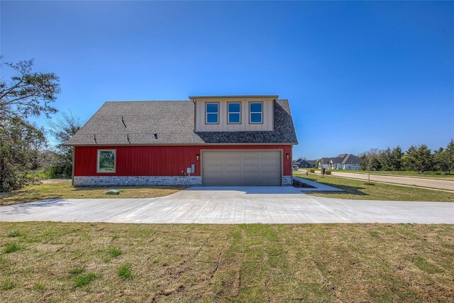 view of front of house with a front lawn, roof with shingles, a garage, and concrete driveway